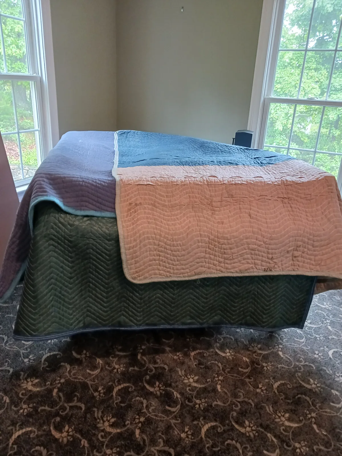 A grand piano wrapped in moving blankets.