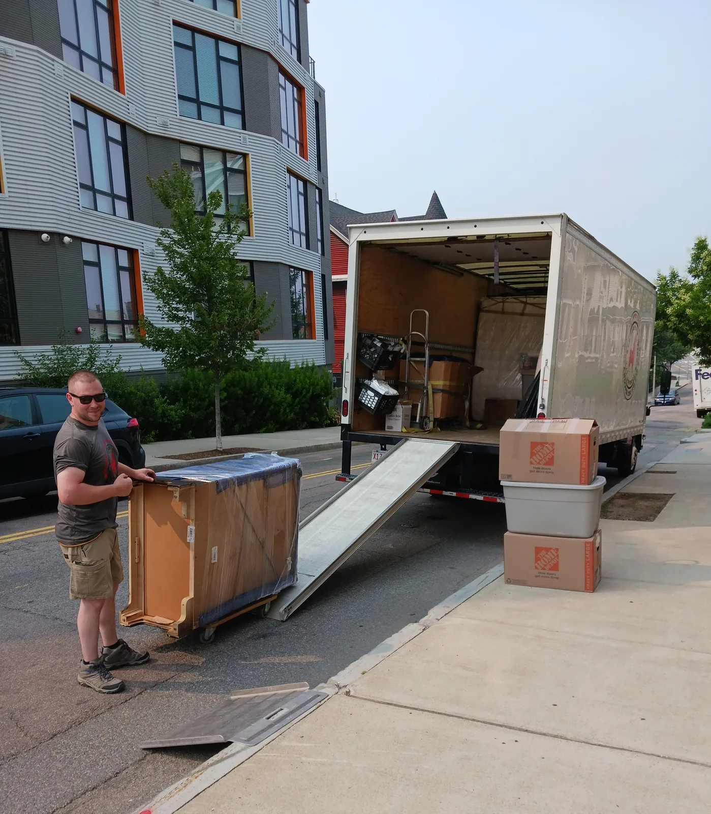 Red Llama mover loading a crate beside the truck.