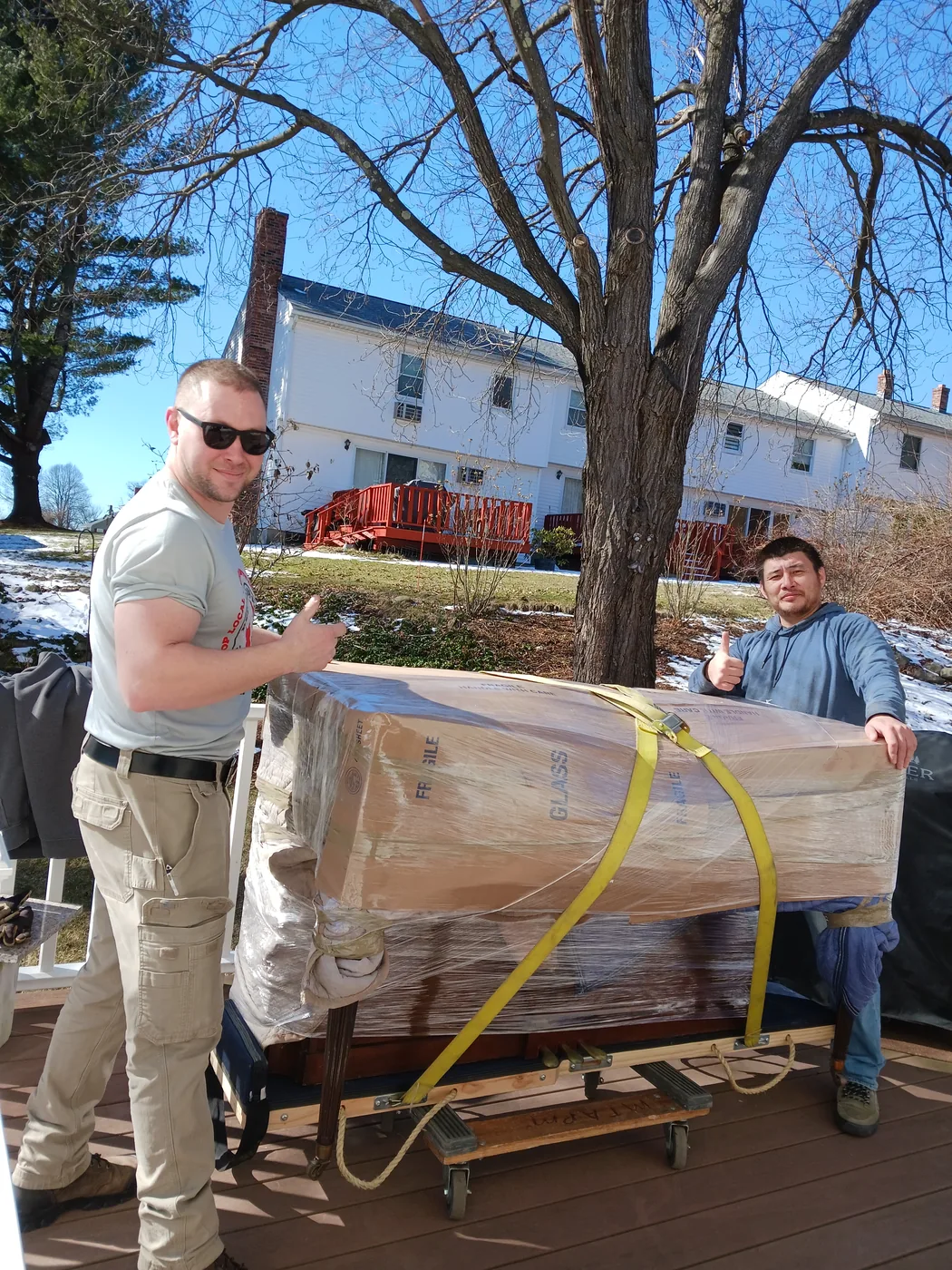 Red Llama movers handling a blanket-wrapped household item.